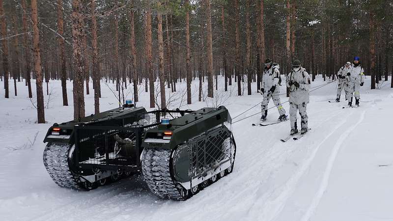 Gebirgsjäger sind mit Seilen an dem unbemannten Fahrzeug befestigt und lassen sich von ihm ziehen. Bundeswehr/Alexander Harms Blauer Bund