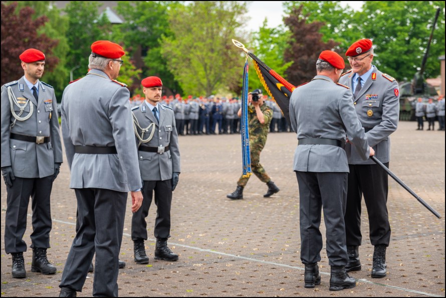 Der Kommandeur des Ausbildungskommandos, Generalmajor Michael Hochwart, überreicht die Truppenfahne der Technischen Schule des Heeres von Brigadegeneral Klaus-Dieter Cohrs (2.v.l.) an Brigadegeneral Dirk Kipper (r.). Foto: Bundeswehr/Lara Drießen - Blauer Bund