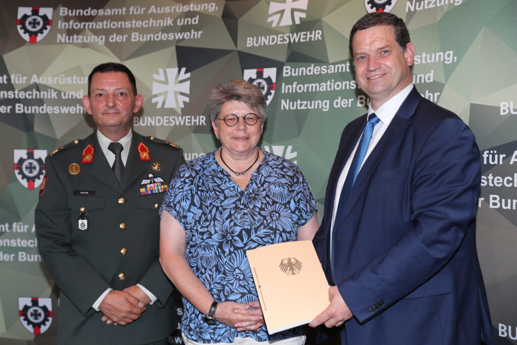 Die Präsidentin des BAAINBw, Annette Lehnigk-Emden, gemeinsam mit dem stellvertretenden Befehlshaber des niederländischen "Commando Materieel en IT", Major General Ludy Schmidt und dem Geschäftsführer der Firma Rheinmetall Landsysteme GmbH, Dr. Björn Bernhard, nach der Vertragsunterzeichnung zum Einsatzsystem "Luftlandeplattformen". – Blauer Bund