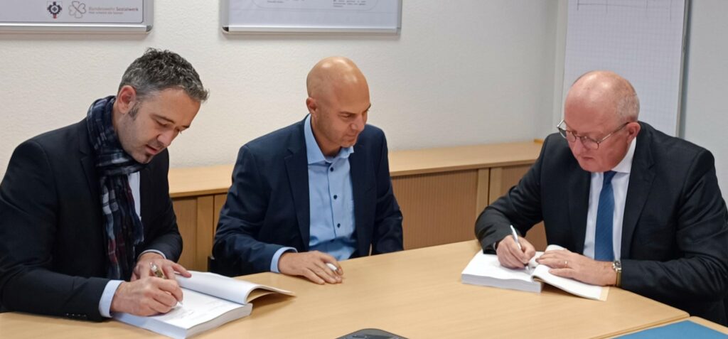 Vertreter der Rolls-Royce Solutions GmbH und der Abteilungsleiter i.V. der Abteilung E des BAAINBw, Gerhard Raspiller (3.v.l.) unterzeichneten gemeinsam den Vertrag über die Lieferung von 53 Triebwerken für den Schützenpanzer Puma. Blauer Bund